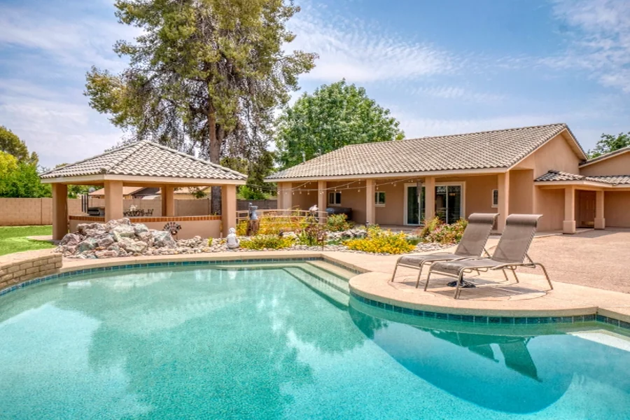 home value pool yard Backyard pool and patio behind a single-story home
