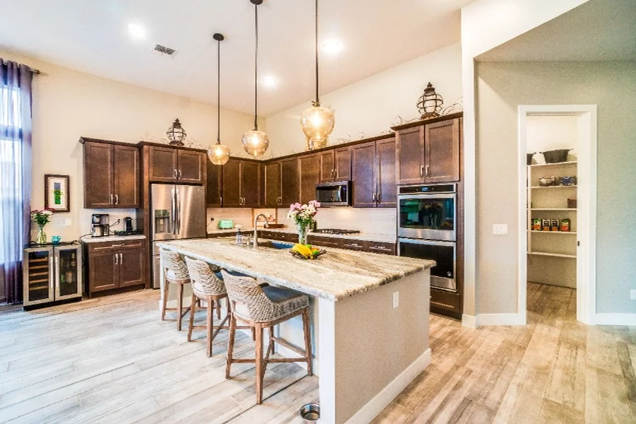 home value step 03 kitchen Kitchen island with woven stools and glass pendant lights