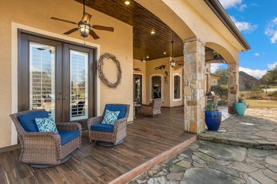 home value step 04 patio Covered patio with blue swivel chairs and a stone column