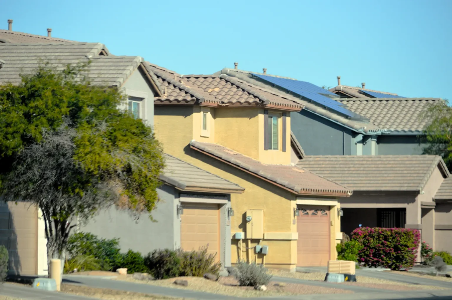 seller step 01 homes Row of stucco homes with solar panels on a sunny street